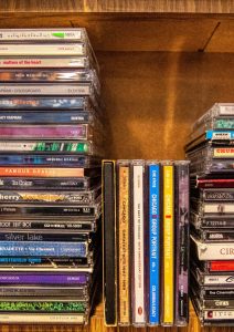 assorted cd case on brown wooden shelf